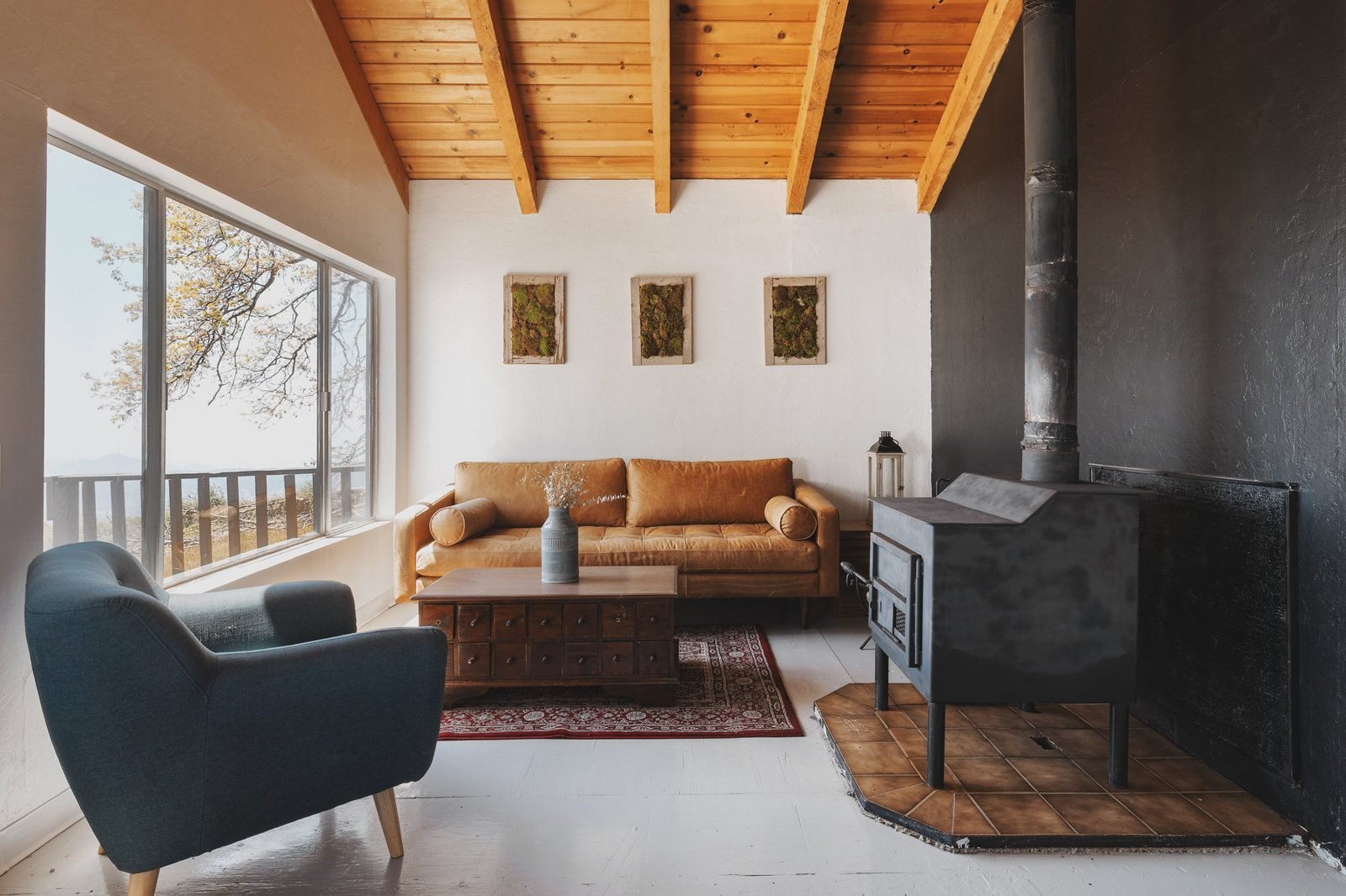 A bright living room with a wood stove and leather sofa