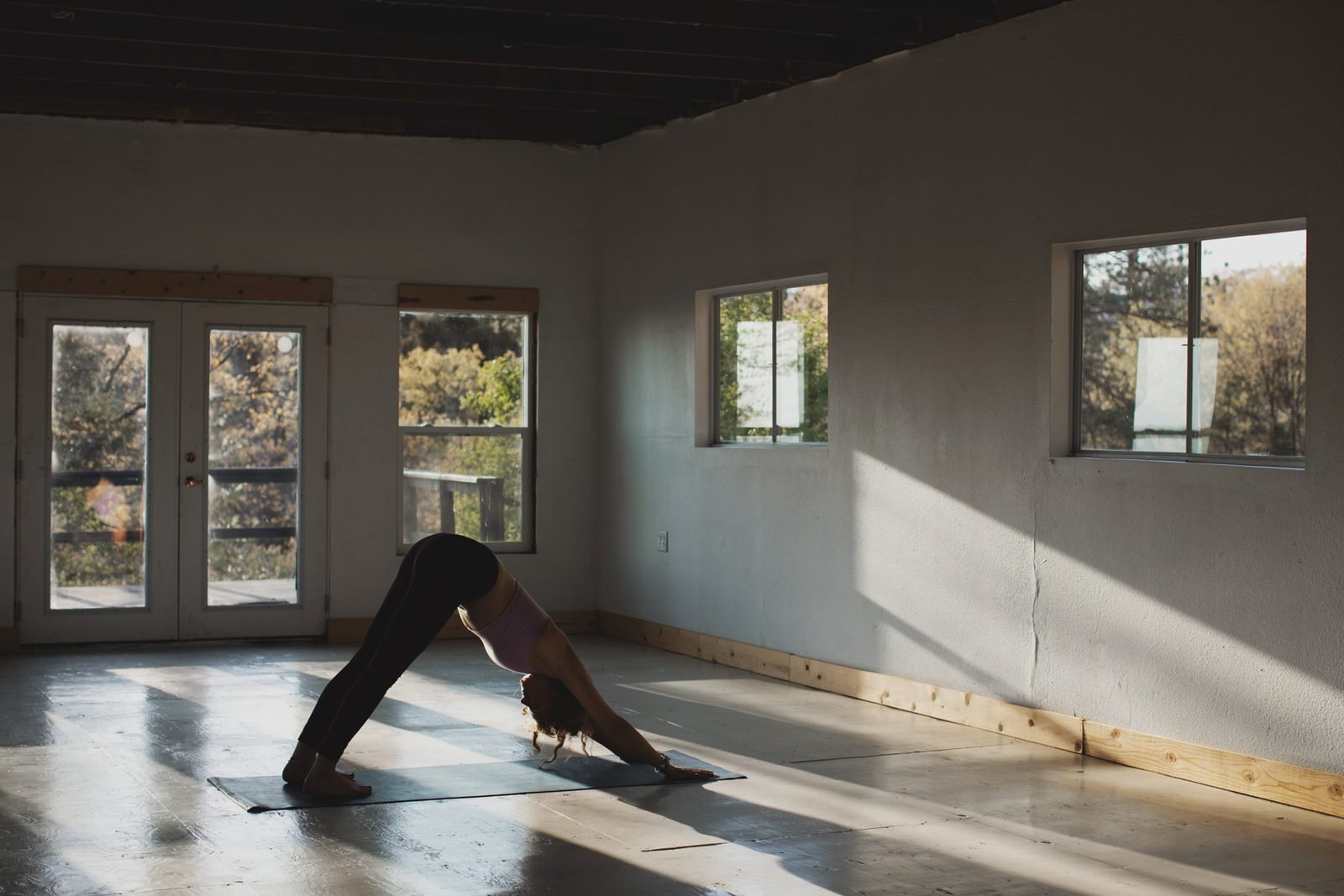 A bright indoor studio with a person in a yoga pose